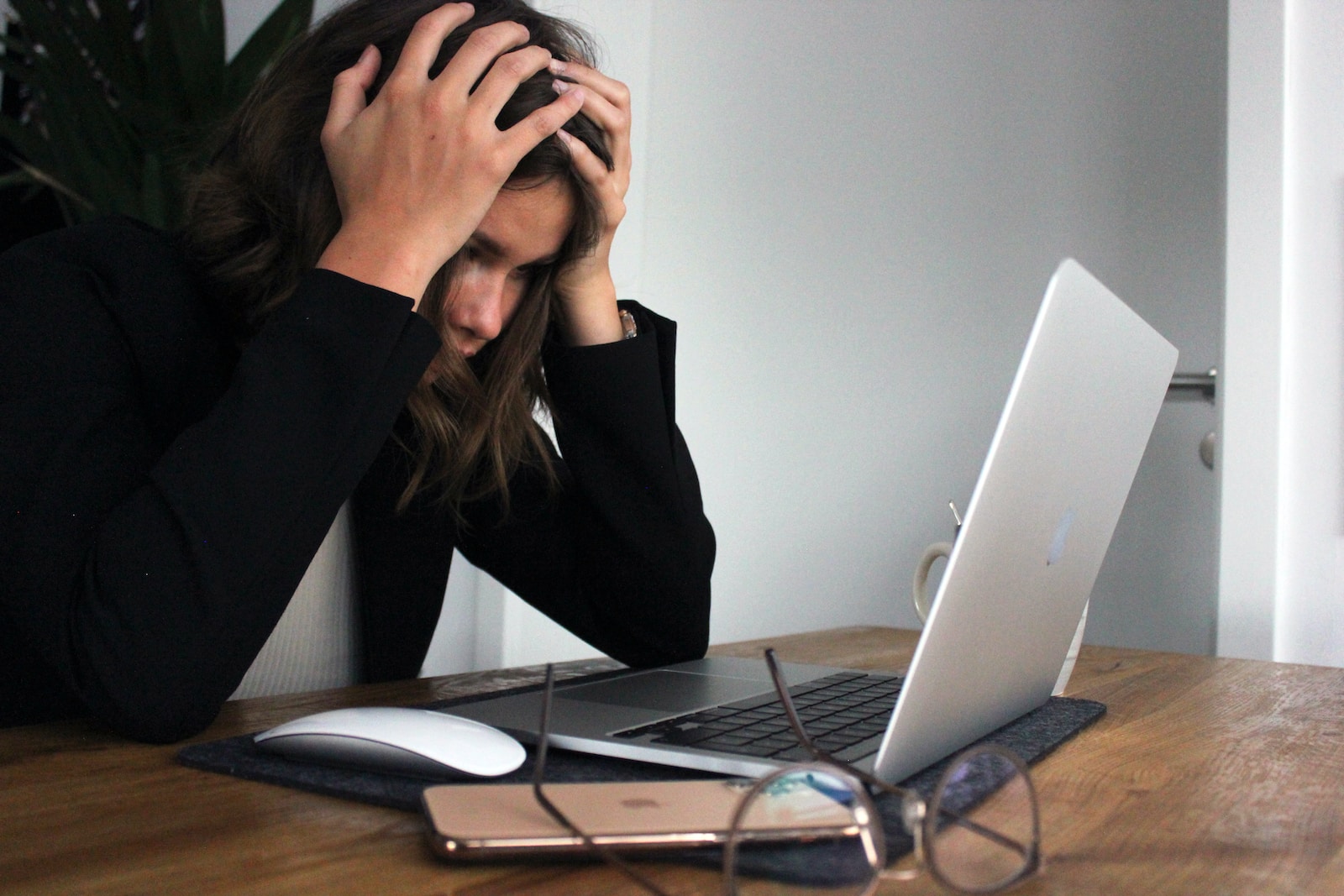woman looking at her laptop screen showing signs of stress and its impact on her mental health